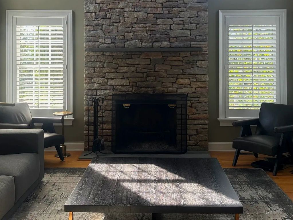 Plantation shutters on the sides of a fireplace.