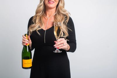 Mandy at The Spa at Salon M holding a bottle and a glass of champagne