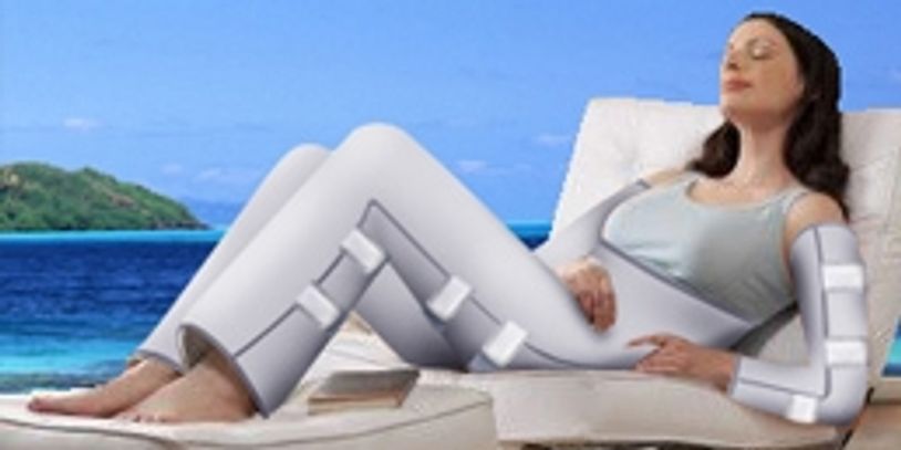 Woman relaxing on a lounge chair wearing a full-body compression suit by the sea.