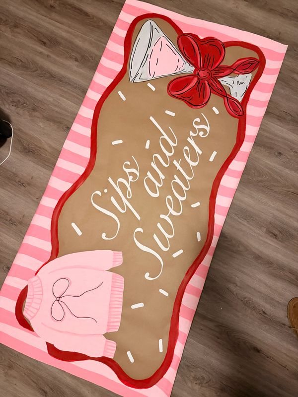A festive towel with a gingerbread design and the phrase 'Sips and Sweaters'.