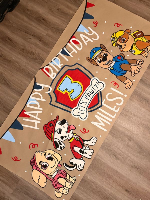 Colorful birthday banner featuring Paw Patrol characters and a 'Happy 3rd Birthday Miles' message.