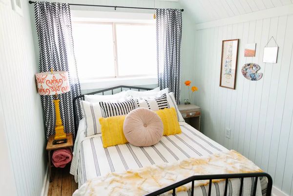 Cozy bedroom with striped bedding and yellow accents.