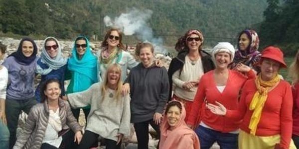 Group of women enjoying outdoors, some wearing colorful scarves.