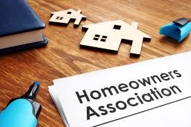 A document titled 'Homeowners Association' with house-shaped cutouts and stationery on a wooden table.