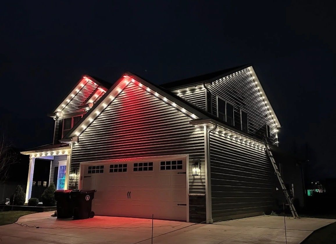 House decorated with white and red Christmas lights at night.