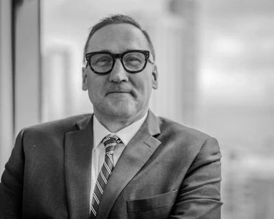 A professional man in glasses and a suit with a confident and sexy expression.