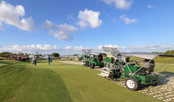 3 Drill and Fill Aerators drilling and backfilling on a golf course green.