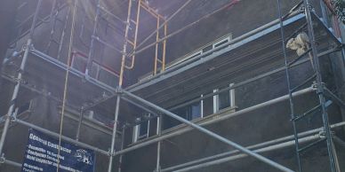 Building under construction with scaffolding and a window.