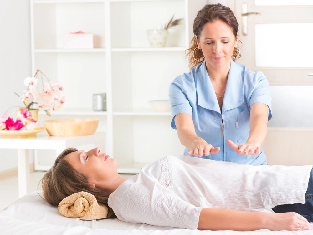 Woman on massage table receiving a reiki treatment
