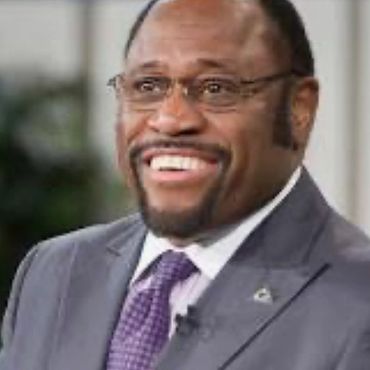 Smiling man in a suit and glasses.