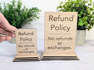 Wooden signs stating no refunds or exchanges in refund policy.