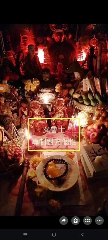 昏暗红光下的供品和神像摆设。