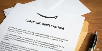 Cease and desist notice from Amazon on a wooden table.