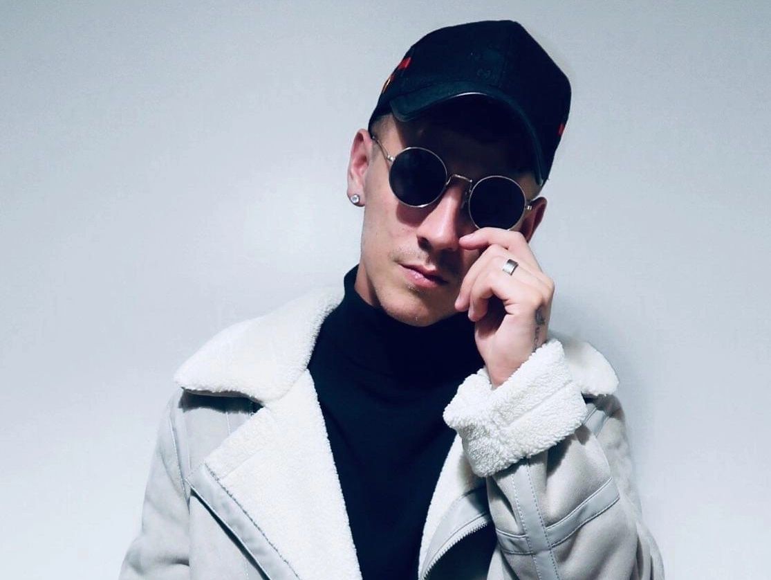 Profile picture of Luke, wearing a black turtle neck with a black gucci hat and glasses.