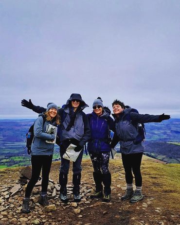 Women summiting mountain in winter uk