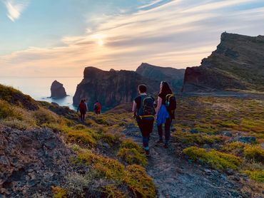 Women hiking at sunrise on the coastal cliffs