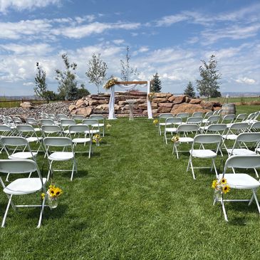 Wedding ceremony chairs set in the grass with the mountain view in the background.