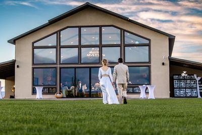 Bride and groom standing in the lawn in front of the venue.