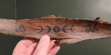 a section of tree bark is laser etched with the phases of the moon, an invitation to retreat rhythms