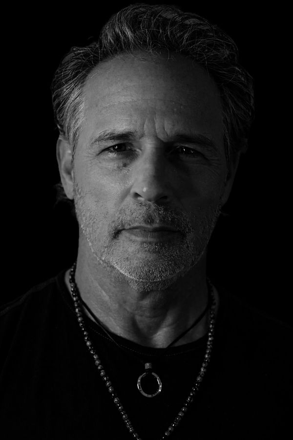 Black and white portrait of a middle-aged man with a contemplative expression.
