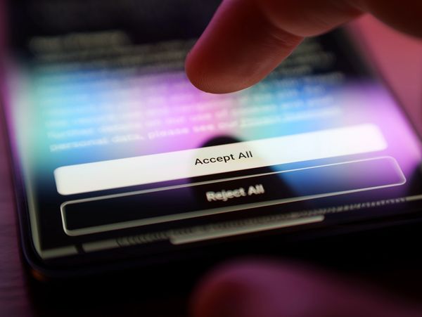 A finger about to tap 'Accept All' on a smartphone screen.