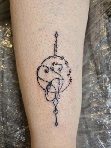 Delicate abstract black ink tattoo on lower leg.