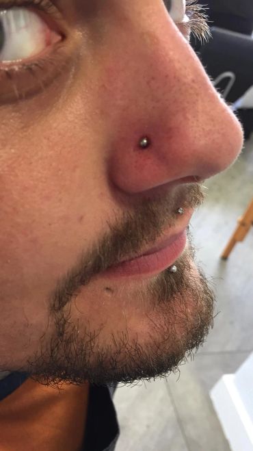 Close-up of a man with facial piercings.