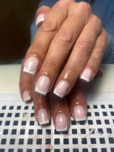 Clean French manicure with white tips on natural nails.