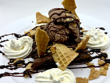 Warm brownie, chocolate ice cream, warm fudge, crushed waffle cone pieces, and whip cream 