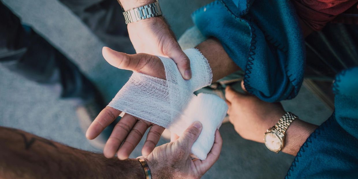 A patient who has injured their hand playing sports and is being treated by a physiotherapist