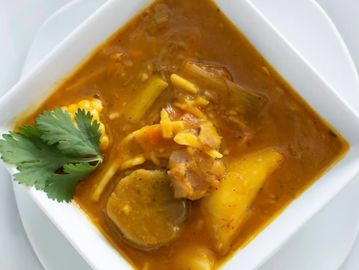 Hearty bowl of vegetable stew with plantains and cilantro garnish.