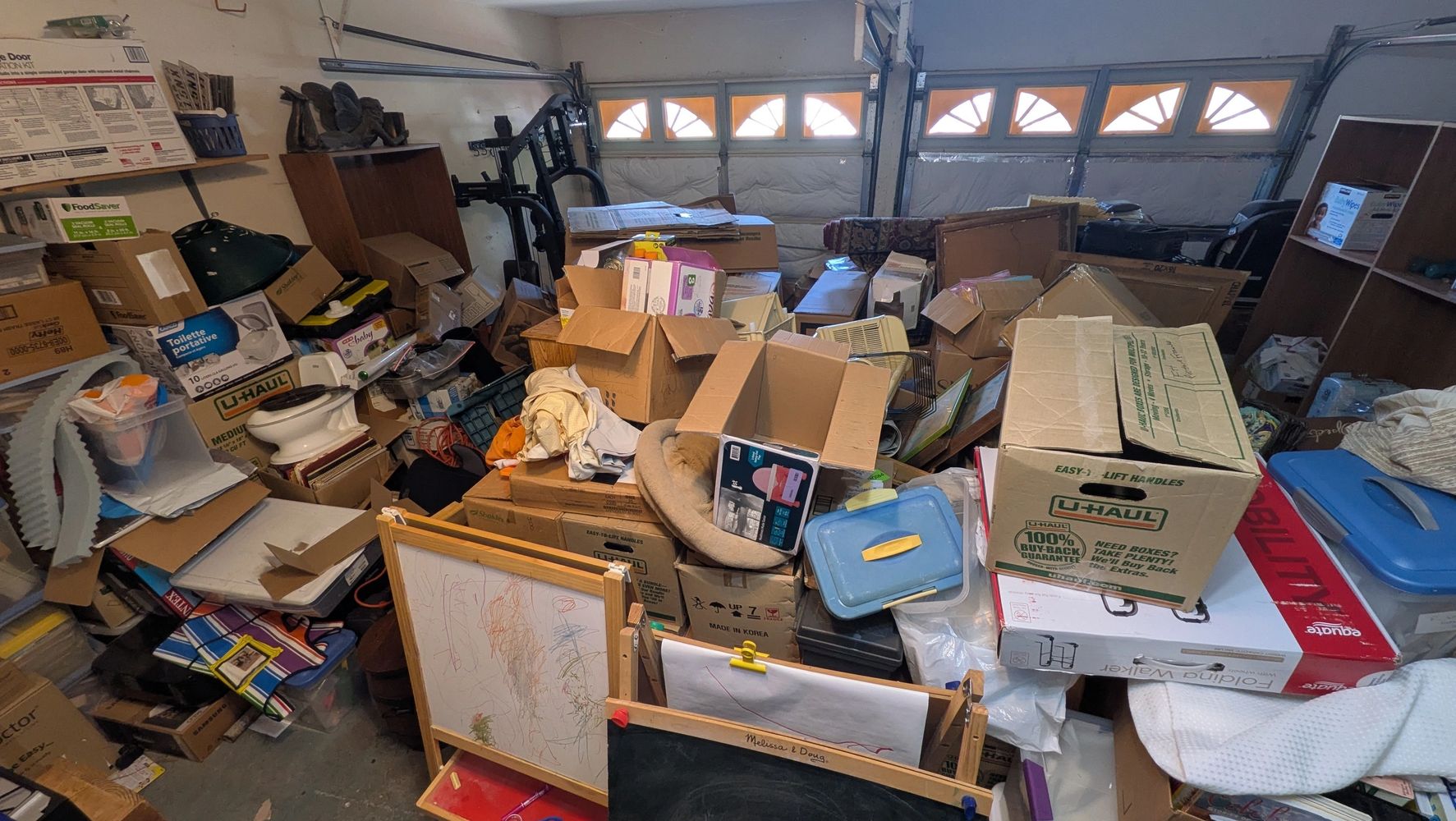 A photo of a garage completely filled with boxes and stacks of personal items. 