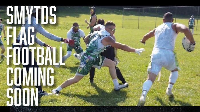 Players in action during a flag football game on a sunny field.