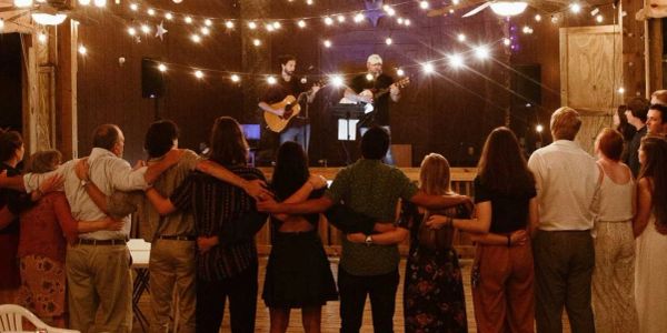 Group of people united in an indoor event with live music.
