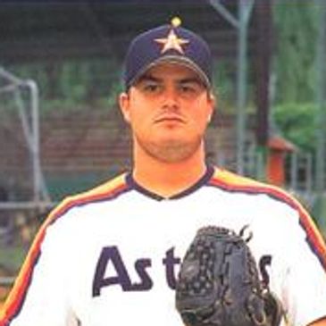 Baseball player in Astros uniform holding a glove.