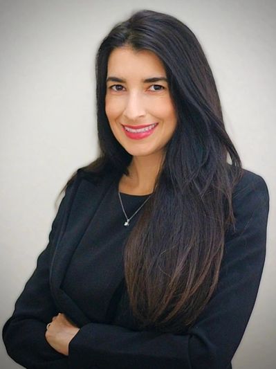 Professional woman with long dark hair smiling confidently.
