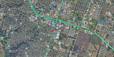 Satellite view of a city with parks, schools, and commercial areas.