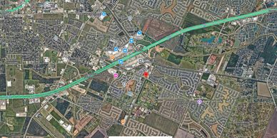 Aerial view of a suburban area with highways, parks, and residential neighborhoods.