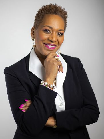 Confident professional woman in a black blazer with a friendly smile.