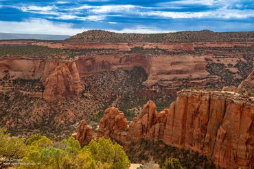 Red rock canyon landscape under a blue sky with scattered clouds.