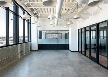 Empty modern office space with large windows and glass doors.