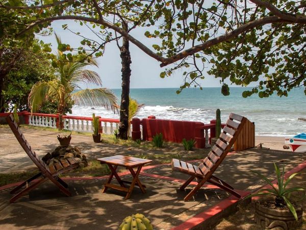 Cozy beachside seating area with wooden chairs and ocean view.