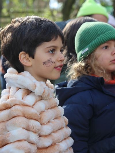 Two children dressed warmly, one with face paint and a furry jacket.