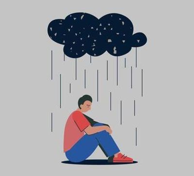 A man sitting under a dark rain cloud, looking sad.