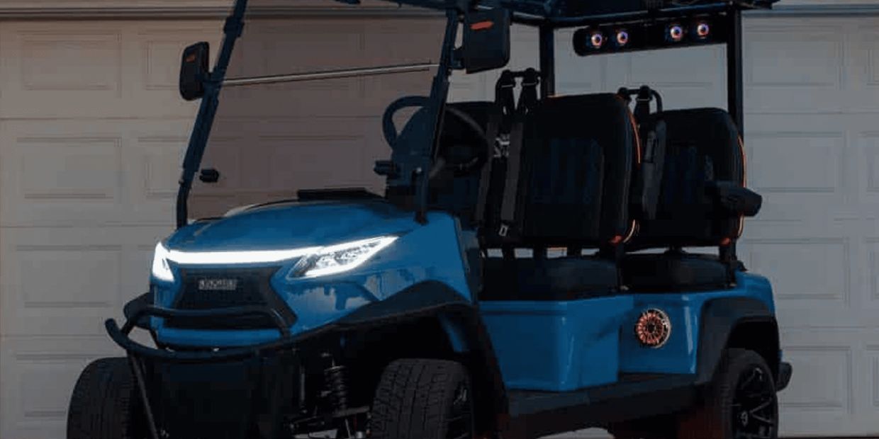 Modern blue golf cart with LED headlights and off-road tires.