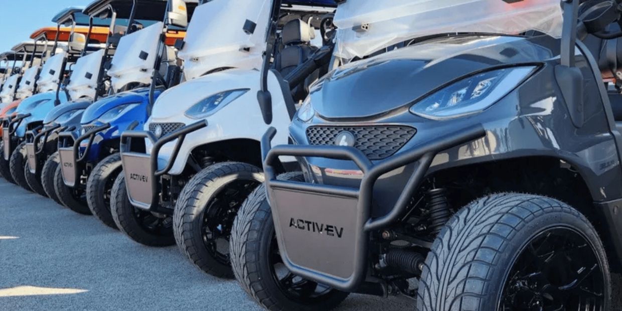 Large inventory of custom Activ-EV electric golf carts in multiple colors lined up at golf cart deal