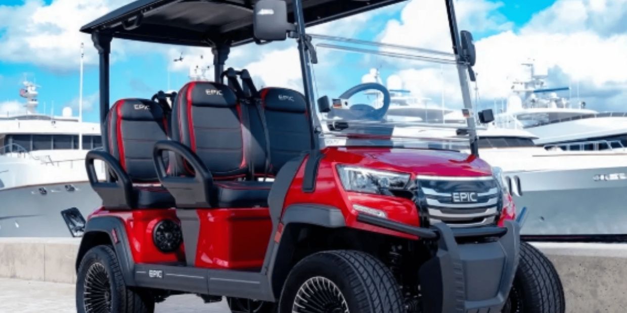 Luxury EPIC electric golf cart in red with black and red sport seats parked at waterfront yacht mari