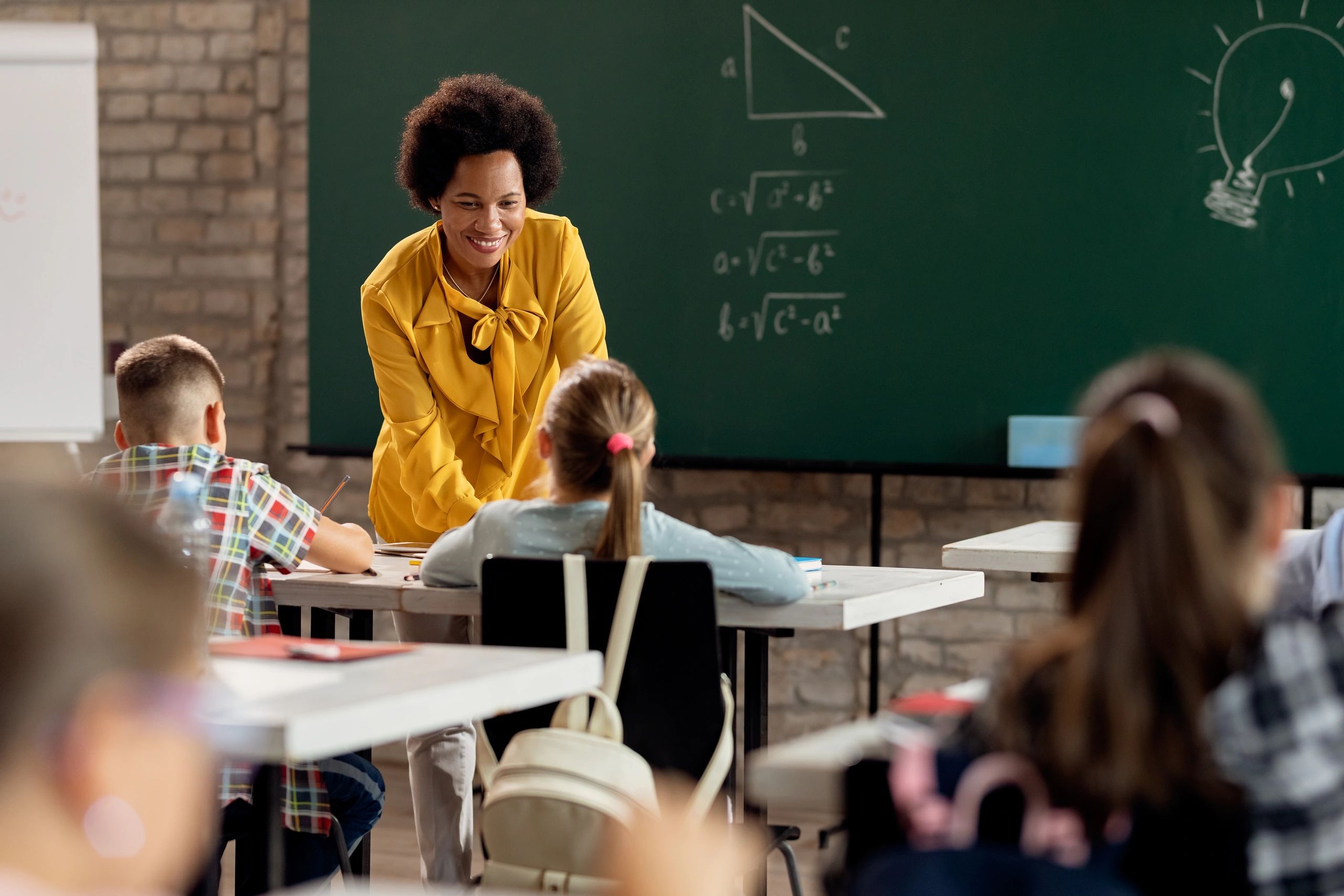 Teacher engaging with students in a classroom during a math lesson.