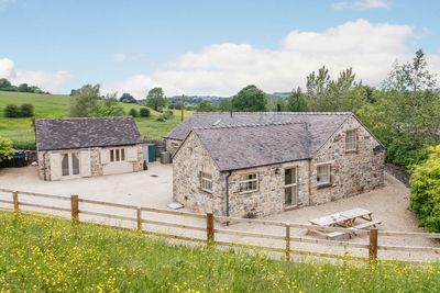 Charming stone cottages in a peaceful countryside setting with greenery around.