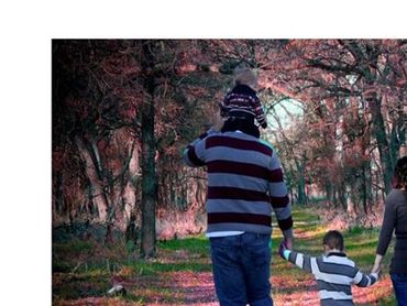 Man woman with child hold the hands and walking in the garden